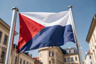 Drapeau de la République tchèque sur mât métallique avec ses couleurs blanc, rouge et bleu distinctives